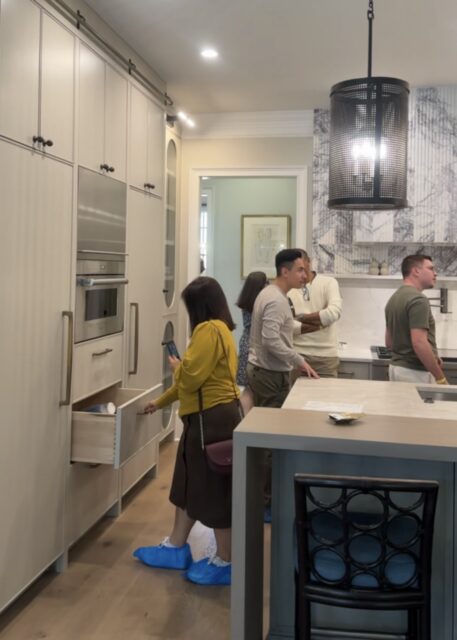 Kitchen with light gray cabinetry, stainless steel appliances, and marble backsplash.