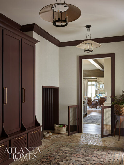 Dark wood built-in cabinetry with brass hardware, textured walls, and two pendant lights.
