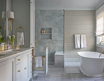 Gray marble bathroom with freestanding tub, double vanity, and built-in linen storage.