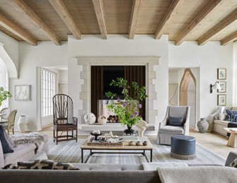 Large living room with exposed wooden beams and stone fireplace.