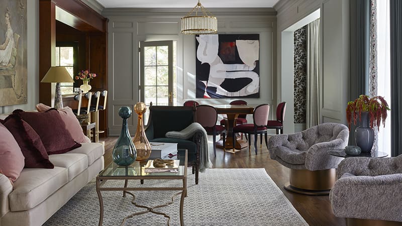 Gray-toned living room with a sofa, chairs, and artwork.