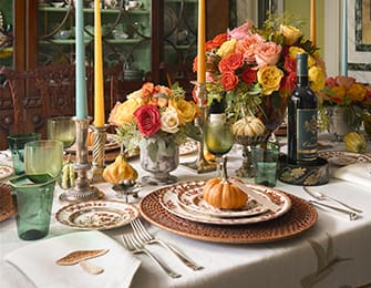 Dining table with floral arrangement, wine, and tableware.