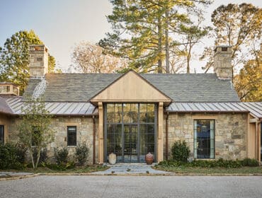 Stone and wood home with a gabled roof and metal accents.