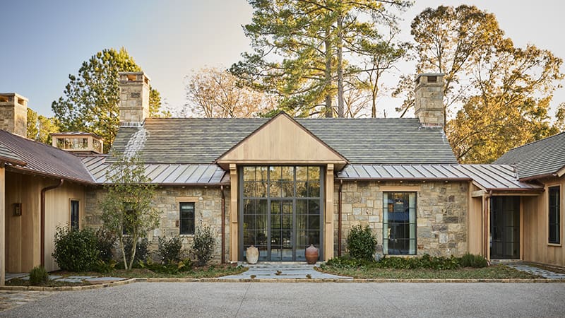 Stone and wood home with a gabled roof and metal accents.