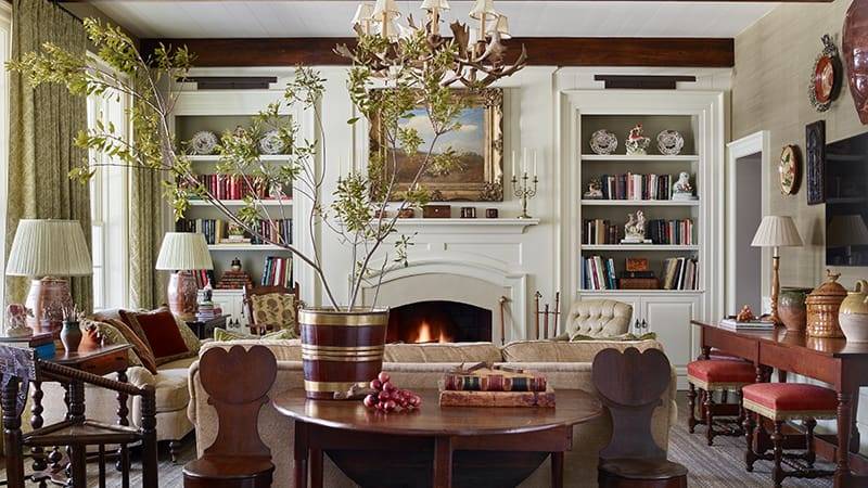 Living room with built-in bookshelves, a fireplace, and a large chandelier.