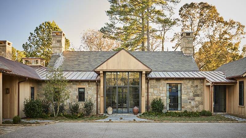 Stone and wood home with a gabled roof and metal accents.
